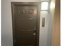 Apartment unit front door with new lock system and modern lighting fixture at 14501 Grove Resort Ave # 1407, Winter Garden, FL 34787