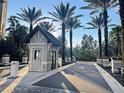 Well-maintained guard house at the entrance of a community with manicured landscaping and palm trees at 14501 Grove Resort Ave # 1407, Winter Garden, FL 34787