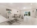 Bright dining area with glass table, white chairs, and view of the living room at 2033 Canny Cv, Winter Park, FL 32792