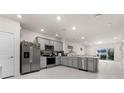 Spacious kitchen featuring gray cabinets, stainless steel appliances, and an island at 2033 Canny Cv, Winter Park, FL 32792
