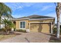 Tan one-story house with two-car garage, landscaping, and palm trees at 2158 Stillwood Way, St Cloud, FL 34771
