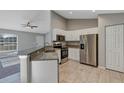 Modern kitchen featuring white cabinets, granite countertops, stainless steel appliances, and tiled flooring at 43 Water Track Dr, Ocala, FL 34472