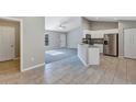 Open-concept living area with a view of the kitchen, tiled floors, and a carpeted living room at 43 Water Track Dr, Ocala, FL 34472