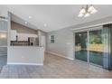 Bright and airy living space with tile flooring, sliding glass doors, and seamless flow into the kitchen at 43 Water Track Dr, Ocala, FL 34472