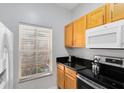 Kitchen with wood cabinets, granite counters, and appliances at 8519 Bay Lilly Loop, Kissimmee, FL 34747
