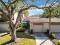 Front view of townhouse with driveway, landscaping, and mature trees at 925 Wintergreen Blvd, Fern Park, FL 32730