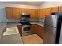 Kitchen with wood cabinets, stainless steel appliances and double sink at 9714 Nonacrest Dr, Orlando, FL 32832