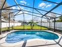 Refreshing screened-in pool with water features, surrounded by a lush backyard and privacy fence at 1101 Maidenmoor Rd, Winter Garden, FL 34787