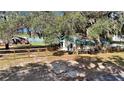 Exterior view of a charming cottage with a fenced yard and mature trees providing shade at 15040 Ne 248Th Avenue Rd, Fort Mc Coy, FL 32134