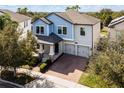 Two-story house, light blue exterior, two-car garage, brick driveway at 15233 Night Heron Dr, Winter Garden, FL 34787