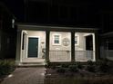 Well-lit house exterior at night, featuring a front porch with rocking chairs and a landscaped walkway at 1563 Cross Prairie Pkwy, Kissimmee, FL 34744