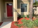 Red front door with Hello mat, red mulch, and landscaping at 2292 Grantham Ave, Davenport, FL 33837