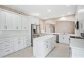 Spacious kitchen with an island, stainless steel appliances, ample white cabinetry, and modern design elements at 231 Chestnut Ridge St, Winter Springs, FL 32708