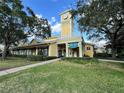 Inviting commercial building with clock tower, manicured lawn, and easy sidewalk access at 2328 Midtown Ter # 1024, Orlando, FL 32839