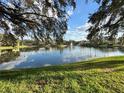 Scenic view of a tranquil pond with a fountain, surrounded by lush green grass and trees at 2328 Midtown Ter # 1024, Orlando, FL 32839