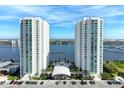 An aerial view of the two white highrise condo towers on the water with a parking garage in front at 241 Riverside Dr # 201, Daytona Beach, FL 32117