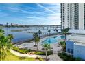 A nice community pool with lounge chairs and palm trees with a view of the bay and nearby bridge at 241 Riverside Dr # 201, Daytona Beach, FL 32117