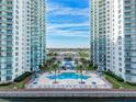 Aerial view of the community pool and entrance to the condos with palm trees and ample seating at 241 Riverside Dr # 201, Daytona Beach, FL 32117