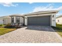 Charming single-story home with a two-car garage, well-maintained lawn, and beautiful brick driveway at 2496 Pine Preserve Ct, St Cloud, FL 34771