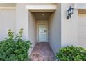 Inviting covered front door entrance with a brick walkway and lush landscaping at 253 Golden Sands Cir, Davenport, FL 33837