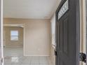 A foyer featuring tile floors, neutral walls, and natural light streaming through the decorative front door at 451 Rogers St, Orlando, FL 32811