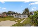 Quaint one-story home with a spacious front yard, long driveway, and classic window designs at 451 Rogers St, Orlando, FL 32811