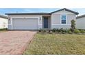 Charming single-story home featuring a brick driveway, attached garage and freshly landscaped front yard at 4543 Sidesaddle Trl, St Cloud, FL 34772