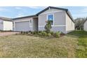 View of a single-story home featuring an attached garage and manicured front yard landscaping at 4543 Sidesaddle Trl, St Cloud, FL 34772