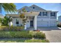 Charming two-story home with a welcoming front porch, manicured garden, and a three-car garage enhancing curb appeal at 4608 Egg Harbor Dr, Kissimmee, FL 34746