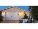 Charming single-Gathering home features a two-car garage, complemented by a white picket fence and fresh landscaping at 482 Hildalgo Dr, The Villages, FL 32159