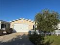 Charming home with a two-car garage, complemented by a white picket fence and lush front yard at 482 Hildalgo Dr, The Villages, FL 32159