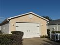 Attached two-car garage with a white door and traditional hardware on a sunny day at 482 Hildalgo Dr, The Villages, FL 32159