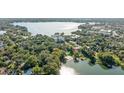 An aerial view of a lakeside community with mature trees, a lake and a condo complex at 690 Osceola Ave # 604, Winter Park, FL 32789