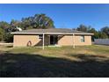 House exterior featuring a covered patio and a grassy backyard at 14476 Se 34Th Ct, Summerfield, FL 34491