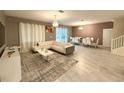 Spacious living room with white sectional sofa and large windows at 1584 Sandbagger Dr, Davenport, FL 33896
