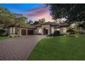 Elegant house exterior at twilight, showcasing landscaping and driveway at 1829 Brackenhurst Pl, Lake Mary, FL 32746