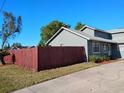 Home featuring green exterior, bright trim, new roof, and mature red wooden fence at 1886 Elkcam Blvd, Deltona, FL 32725
