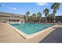 Community pool surrounded by mature palm trees and lounge chairs offering a relaxing resort style feel at 1928 Conway Rd # 40, Orlando, FL 32812