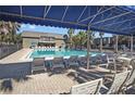 Inviting community pool with lounge chairs, a shaded area, and tables for residents to relax and socialize at 1928 Conway Rd # 40, Orlando, FL 32812