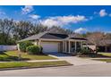Tan house with a two-car garage and landscaping at 2147 Sunbow Ave, Apopka, FL 32703
