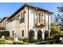 White stucco home with balcony, decorative iron railings, and lush landscaping at 236 Acadia Ter, Celebration, FL 34747