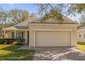 Tan one-story house with a two-car garage and landscaped yard at 2513 Castle Pines St, Clermont, FL 34711