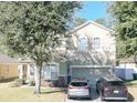 Two-story house with a green facade, stone accents, and a two-car garage at 3260 Sorrel Ct, Deltona, FL 32725