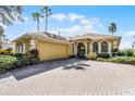 Front view of a yellow house with a large driveway at 4 Arika At Lionspaw, Daytona Beach, FL 32124