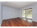 Spacious living room showcasing sleek wood flooring and sliding glass doors to the outdoor patio at 4001 Misty Morning Pl, Casselberry, FL 32707