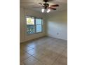 The bedroom features neutral paint, tile flooring, and a ceiling fan for comfort at 607 Waverly Ln # 403, Maitland, FL 32751