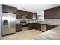 Modern kitchen featuring dark wood cabinets, granite countertops, and stainless steel appliances at 711 Cypress Ave, Orange City, FL 32763