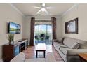 Bright living room featuring hardwood floors, a ceiling fan, and a balcony with outdoor seating at 8020 Tuscany Way # 6401, Davenport, FL 33896