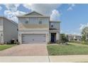Two-story house with gray siding, stone accents, and a two-car garage at 828 Scrub Oak Hammock Rd, Davenport, FL 33837