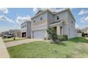 Two-story house with gray siding, stone accents, and a two-car garage at 828 Scrub Oak Hammock Rd, Davenport, FL 33837